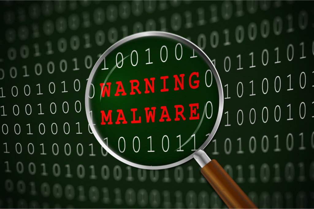 Lupa powiększająca napis Warning Malware na tle zer i jedynek